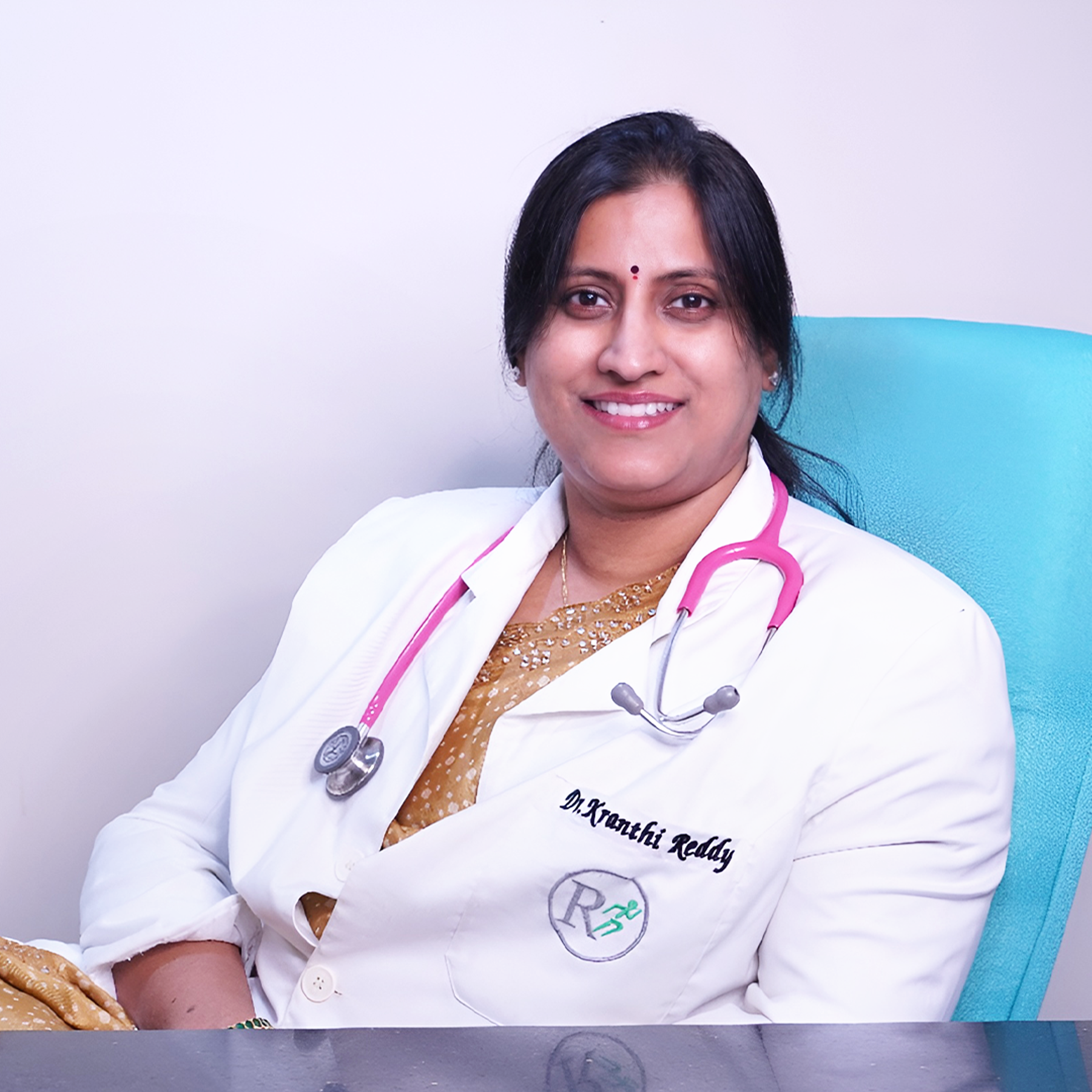 Portrait of Dr. C. Kranthi Reddy, a male Gynaecology and ovarian cancer surgeon, smiling and wearing a white coat, vertical rectangle photo